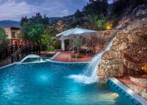 a waterfall in a pool with a water slide at Kallisti Hotel in Potos