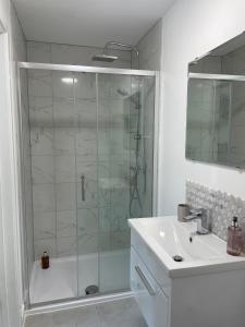a bathroom with a glass shower and a sink at Central, Chic Apartment in Bournemouth