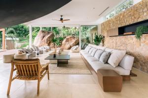 a living room with a stone wall at Anaia in Thongsala