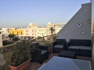 a balcony with a table and chairs and buildings at Salento Sea & Sun Apartment in Porto Cesareo
