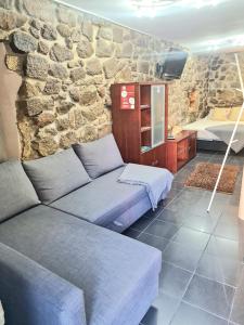 a living room with a couch and a stone wall at Historic House in Braga