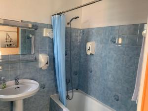 a blue tiled bathroom with a sink and a shower at Le Richelieu in Saint-Jean-de-Monts +15 photos