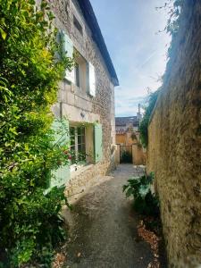 an alley in an old stone building with a window at Maison Le Troubadour in Ribérac