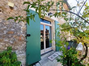 a green door with a sign in front of a building at Maison Le Troubadour in Ribérac