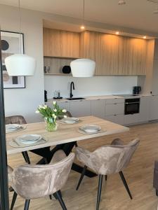 eine Küche mit einem Holztisch und Stühlen in der Unterkunft Apartament Oficer Portova in Gdynia