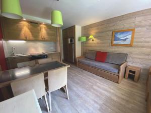 a living room with a couch and a kitchen at Appartement La Tania, 2 pièces, 5 personnes - FR-1-513-77 in La Tania