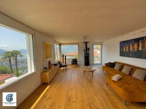 ein Wohnzimmer mit einer Couch und einem Tisch in der Unterkunft Casa Teatro Panoramico 5 Star Holiday House in Locarno + 37 Fotos