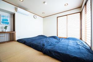 a large blue bed in a room with a window at Free Parking VAMOS A VER御宿 #RK1 in Iwada