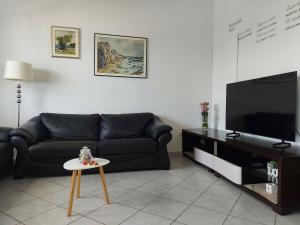 sala de estar con sofá negro y mesa en LARA & VITO, en Metajna