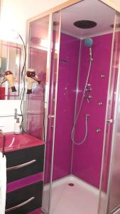 uma casa de banho roxa com um chuveiro e um lavatório em à 10mn des arènes f2 au calme avec garage gratuit em Nîmes