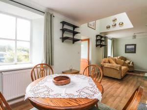 a dining room with a table and a couch at 6 Lowlands in Arisaig