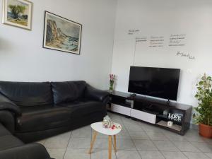 a living room with a black couch and a tv at LARA & VITO in Metajna