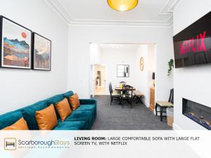 a living room with a couch and a table at Scarborough Stays - Trafalgar Lodge - 4 bedroomed house - Free Parking in Scarborough