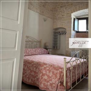 una camera con letto e copriletto rosa di Cummerse Fanizza ad Alberobello