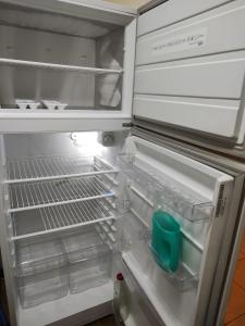an open refrigerator with a green container in it at Studio 7 - Hospital Italiano in Buenos Aires