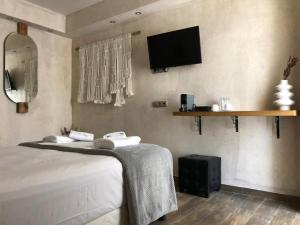 a bedroom with a bed and a tv on the wall at GARDELLI RESORT in Laganas