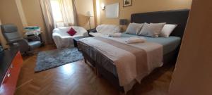 een slaapkamer met een groot bed en een stoel bij Luxury apartment by the sea with private whirlpool and terrace 50m2 in Posedarje