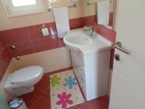 ein kleines Badezimmer mit Toilette und Waschbecken in der Unterkunft Apartments Linda in Trogir + 37 Fotos