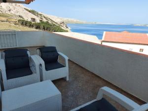 two chairs on a balcony with a view of the ocean at LARA & VITO in Metajna