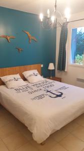 - une chambre dotée d'un grand lit avec des oiseaux sur le mur dans l'établissement APPARTEMENT LES PINS PENCHES Hardelot plage, à Neufchâtel-Hardelot