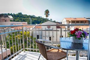 a table with a vase of flowers on a balcony at House Star in Petrovac na Moru +9 photos