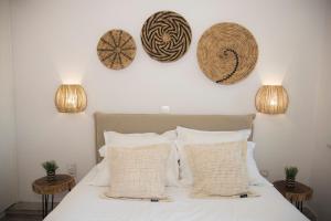 a bedroom with a bed with three baskets on the wall at Ano Siroa in Ano Syros