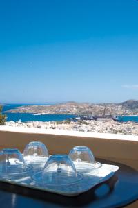 a tray with four clear glasses on a table at Ano Siroa in Ano Syros