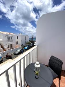 Una mesa y sillas en un balcón con vista a una calle. en BLANCA FRENTE AL MAR, en Punta Mujeres