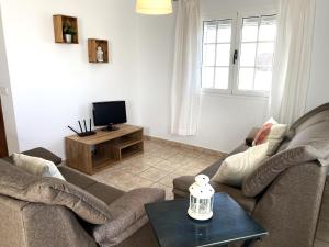 Una sala de estar con dos sofás y un televisor. en BLANCA FRENTE AL MAR, en Punta Mujeres