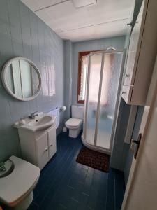 uma casa de banho com um lavatório, um WC e um espelho. em Sant Jordi 2 em Tremp