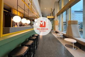 un restaurante con un bar con un letrero que dice cómo se inyecta en MEININGER Hotel Bremen Hauptbahnhof, en Bremen