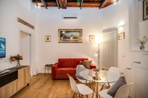 uma sala de estar com um sofá vermelho e uma mesa de vidro em Casa Cancello em Roma