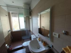 uma casa de banho com um lavatório, um WC e um espelho. em Tirana's Hidden Wonder em Tirana