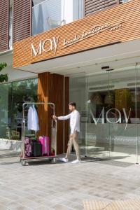 a man standing in front of a store with a suitcase at May Altafulla Beach Boutique Hotel in Altafulla