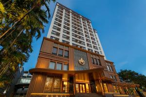 a building in front of a tall building at Amora Thapae Hotel Chiang Mai in Chiang Mai