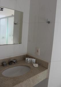 uma casa de banho com um lavatório e um espelho em Tiffany Hotel em Olímpia