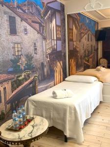 a room with two beds and a painting on the wall at H. Boutique Puerta del Sol in Torrelavega