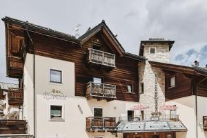 a large wooden building with two balconies on it at Hotel 2000 in Livigno