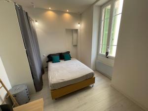 sypialnia z łóżkiem z niebieskimi poduszkami i oknem w obiekcie Nice Renting - Moneghetti Monaco - Spacious Apartment Full Equipped w mieście Beausoleil