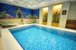 a large swimming pool in a room with a mural at Neorion Hotel - Special Class in Istanbul