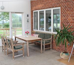 a wooden table and chairs on a patio at Aktivitetshuset Solhjem in Hjørring
