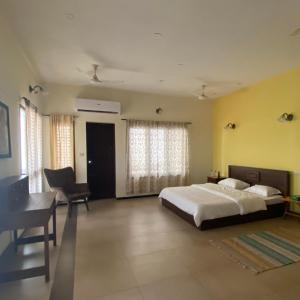 a bedroom with a bed and a desk and a bed sidx sidx sidx at Costa Verde Luxury Seafront Villa in Chennai