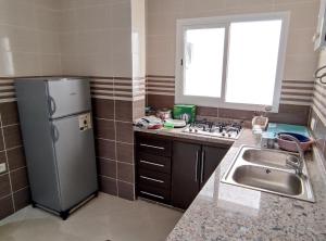 a kitchen with a stainless steel refrigerator and a sink at Appartments Achahbar in Al Hoceïma