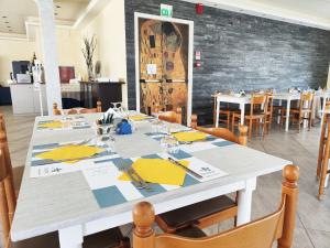 a dining room with a table with yellow napkins at Blu Star Hotel in Gabicce Mare +84 photos