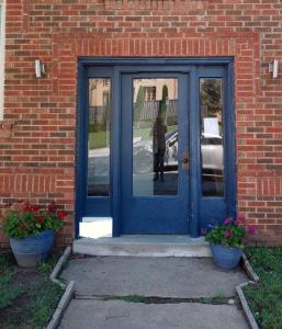 a blue door in a brick building with two potted plants at Cherry Street Vintage Apartment-Free Parking! in Tulsa