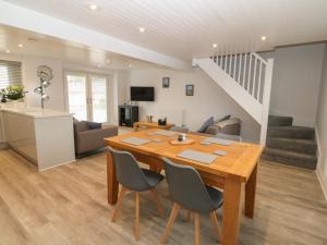 a dining room and living room with a table and chairs at Bryn Eglwys Bach in Llanfairpwllgwyngyll