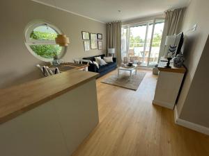a living room with a kitchen and a living room with a couch at Wohnen am Meer in Zingst