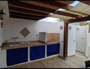 une cuisine avec un évier et un plan de travail avec des armoires bleues dans l'établissement Cottage a 1km dal centro storico, 500 m dal mare,veranda attrezzata, giardino,vista mare, à Carloforte