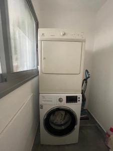 a washer and dryer in a room with a window at SEA & FUN in H̱adera