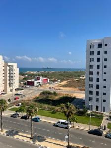 una strada cittadina con palme e un edificio alto di SEA & FUN a Hadera